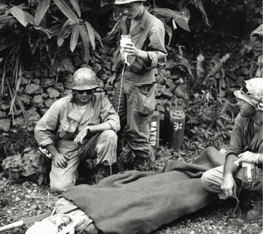 Captain James R. Barron, with Company F, 382nd Infantry Regiment, 96th Infantry Division, receives plasma by frontline aid men after beingwounded by Japanese sniper on Okinawa, April 4, 1945 (National Archives and Records Administration/U.S. Army Signal Corps)
